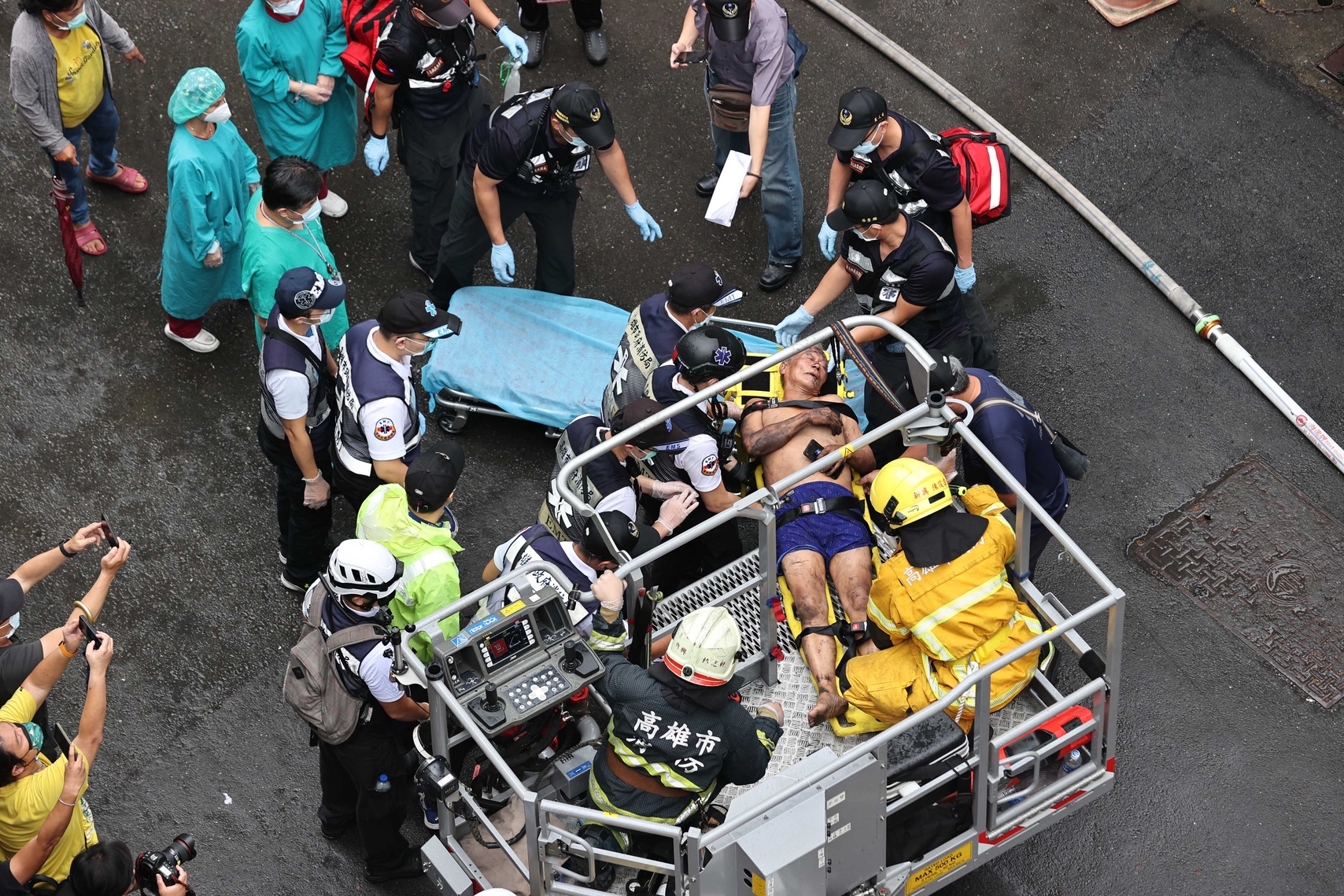 高雄市消防局共出动75车159人赶往失火的“城中城”大楼抢救。消防人员进入大楼逐层搜查,并用云梯车救出受困屋内的民众。(中通社)