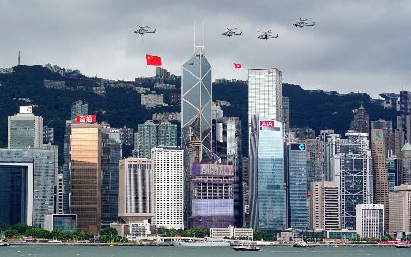 昨天是香港回归中国25周年纪念日，香港特区政府昨早在金紫荆广场举行升旗仪式，悬挂中国国旗和香港区旗的直升机编队飞过维多利亚港上空。（路透社）