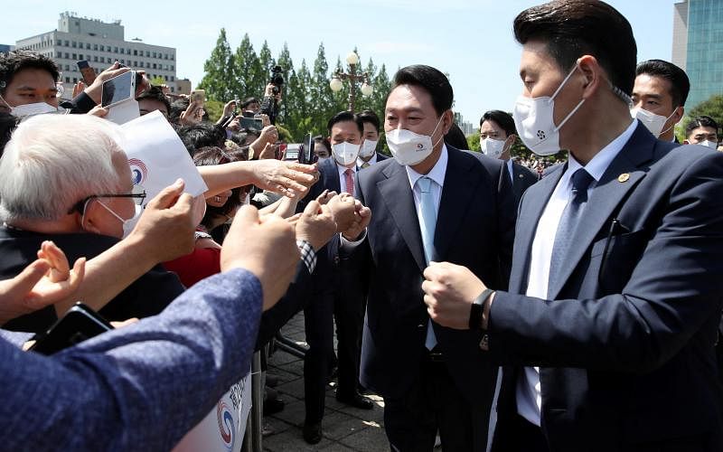 韩国舆论认为新总统尹锡悦（右二）成功塑造了亲民的形象。图为他5月10日出席就职典礼时受到支持民众的热烈欢迎。（路透社）