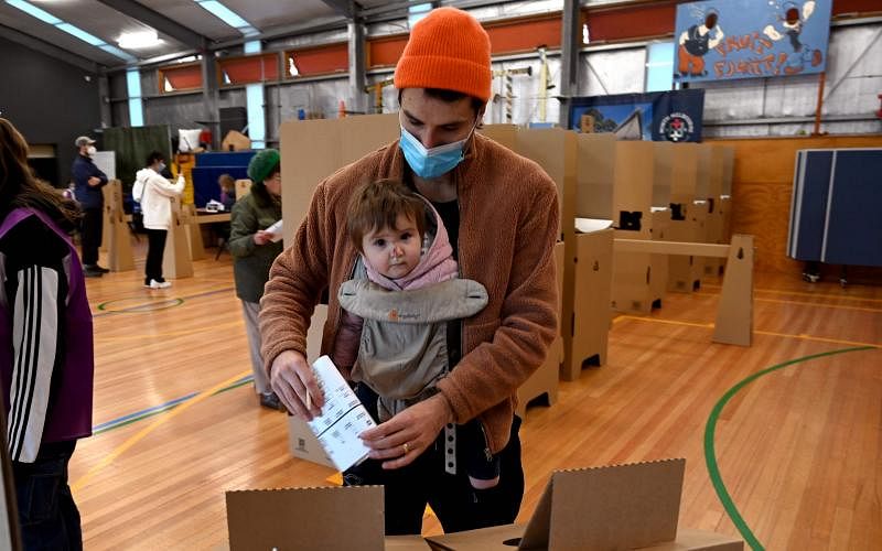 澳洲联邦选举周六投票，图为一名澳洲男子带着宝宝到墨尔本的投票站投票。（法新社） 