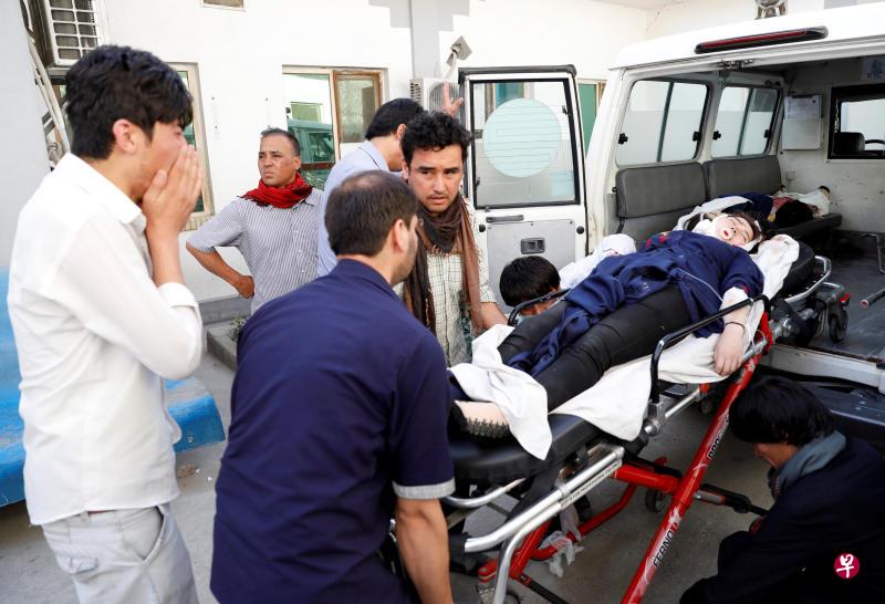 阿富汗救护人员把一名伤者抬上救护车(路透社)