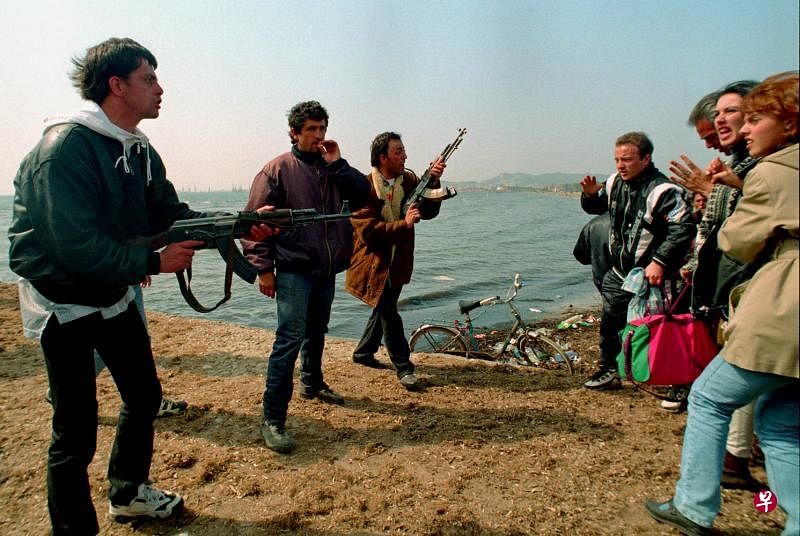 1997年3月,一群阿尔巴尼亚人逃避内战战火,在都拉斯港遭数名持枪男子