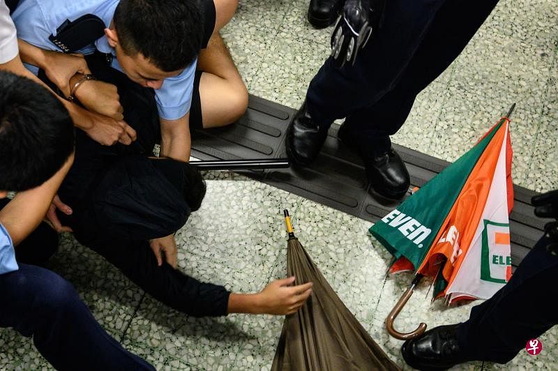 香港警察9月2日在乐富站内制服一黑衣男子,将其压倒在地(法新社)