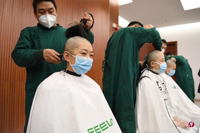保健院医护人员2月15日在奔赴武汉支援疫情防控和救治工作前剃掉头发