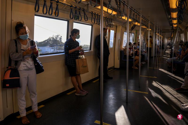 图为公众戴口罩搭地铁保持安全距离.(路透社)